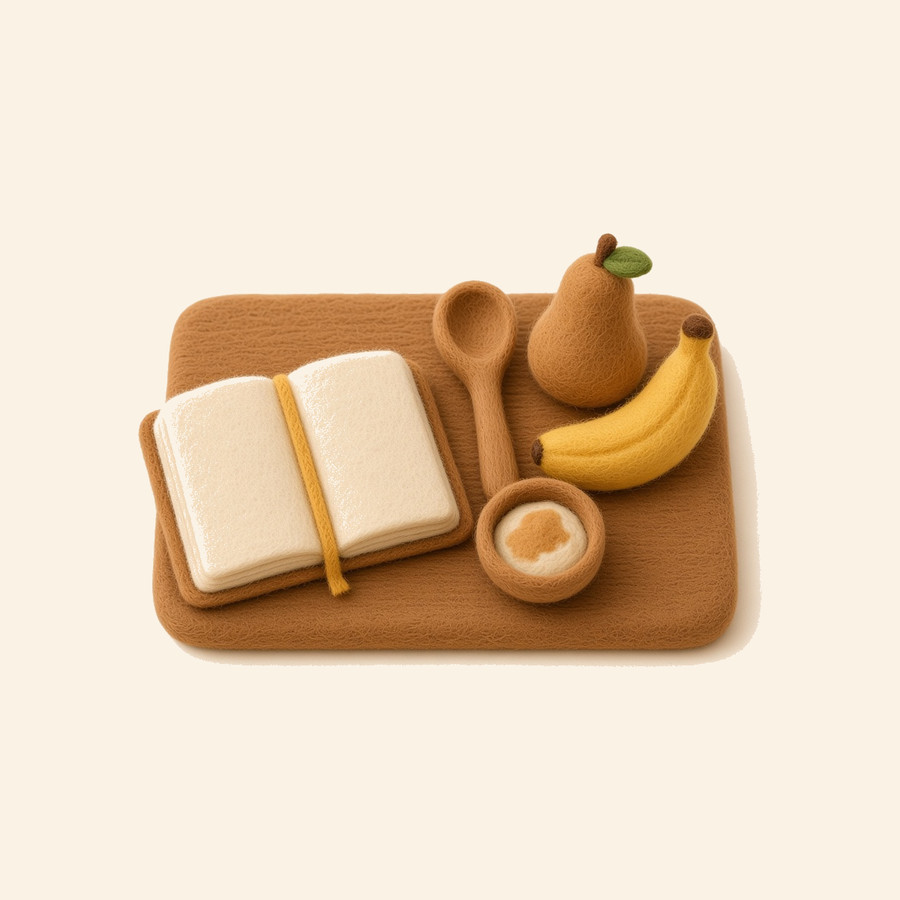 Libro de recetas de fieltro, cuchara de madera, bowl de papilla, banana y pera
